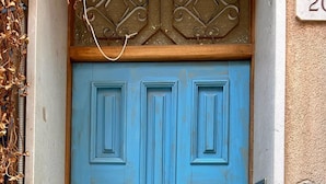 A blue door with a brass knocker, a decorative glass panel above, and a wall-mounted mailbox with numbers 1, 2, and 3. - Casa Di Sylwia (Termini Imerese)