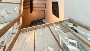 A staircase with a wooden handrail and white steps leading to a landing. - Casa Di Sylwia (Termini Imerese)
