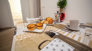 Ein Frühstückstisch mit Gebäck, einer Kaffeekanne und einer Tasse.