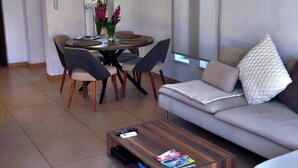 A modern living room with a sofa, coffee table, and dining area. - Aqua Luxe Ayia Napa Protaras Villa With Sea View (Paralimni)