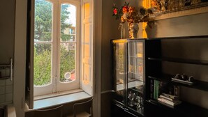 A room with a large window, a black cabinet with glass doors, and a decorative wall piece. - YourHome - Chiara's Apartment Sorrento 3 (Piano di Sorrento)