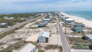 Una zona residenziale sul lungomare, con case, una spiaggia e una strada.