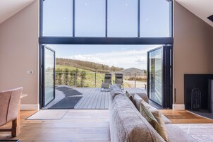 A modern living room with a large sliding glass door leading to an outdoor deck.