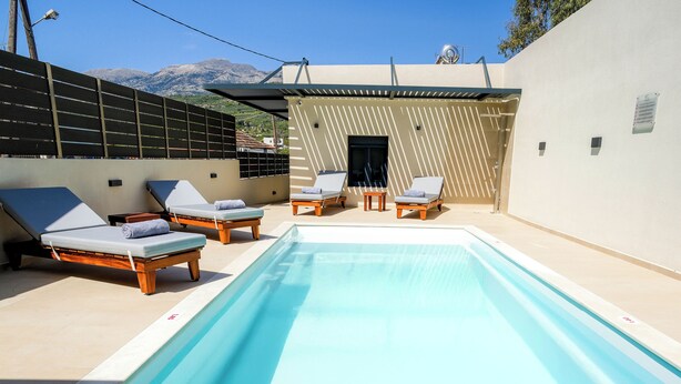 A pool area with lounge chairs and a view of mountains. - Veneto Luxury Residence with pool in Venerato, Crete (Neo Venerato)