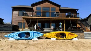 A two-story wooden house with a covered porch and a staircase leading to a balcony. - Lakefront Home w/Hot Tub & Beach – Sleeps 20 (New Lisbon)