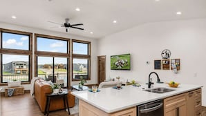 A modern kitchen with a large island, wooden cabinets, and a built-in dishwasher. - Lakefront Home w/Hot Tub & Beach – Sleeps 20 (New Lisbon)