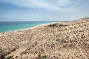 A desert landscape with a beach and a building complex. - Home2Book Esmeralda Beach, Resid. Playa Paraíso (Pajara)