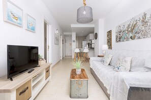 Relax in this stylish living room with a flat-screen TV, comfortable sofa, and a coffee table.