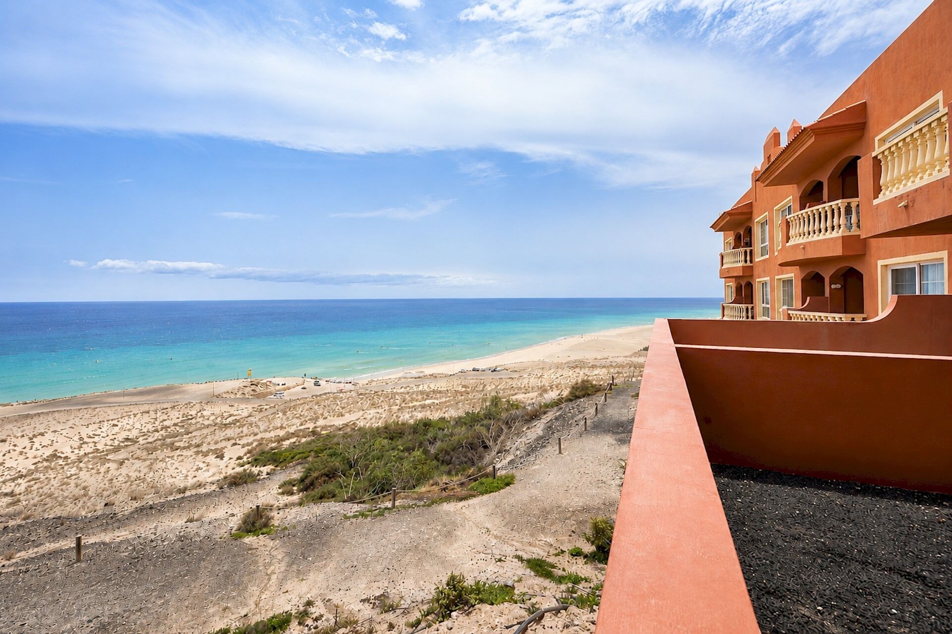 A beachfront hotel with a clear view of the ocean and a sandy beach.