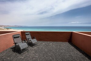 Relax in a secluded seating area with ocean views, a bench, and three chairs.