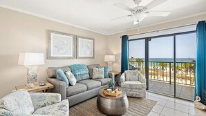 A living room with a grey sofa, two armchairs, a coffee table, and a balcony with a view of the beach. - The Summit 312 (Panama City Beach)