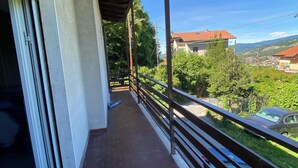 Un balcon avec vue sur la ville et les montagnes.