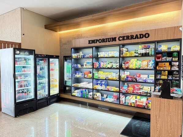 Quiosque de autoatendimento com diversas opções de lanches e bebidas, incluindo bebidas refrigeradas e produtos embalados.