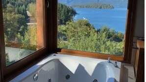 A bathroom with a large window offering a view of a lake and mountains. - Tanière. Contemporary design house. Breathtaking lake view. (Villa La Angostura)