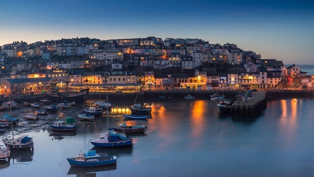 A coastal town at dusk with boats docked in the harbor and buildings along the waterfront. - 3 Bed in Brixham (oc-r31919) (Brixham)