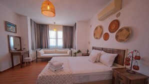 Un dormitorio con una cama grande, mesitas de noche, un escritorio y una silla.