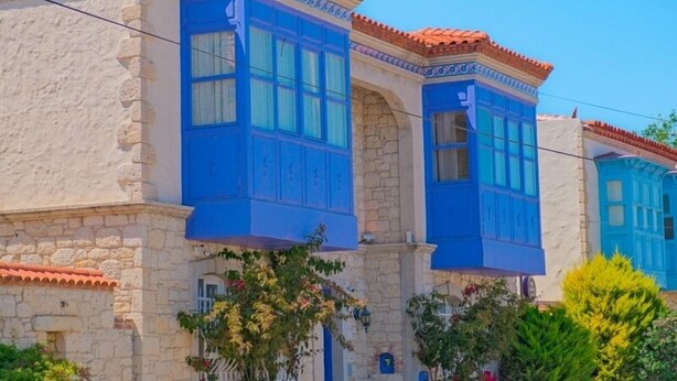 Un edificio con ventanas de marco azul y fachada de piedra.
