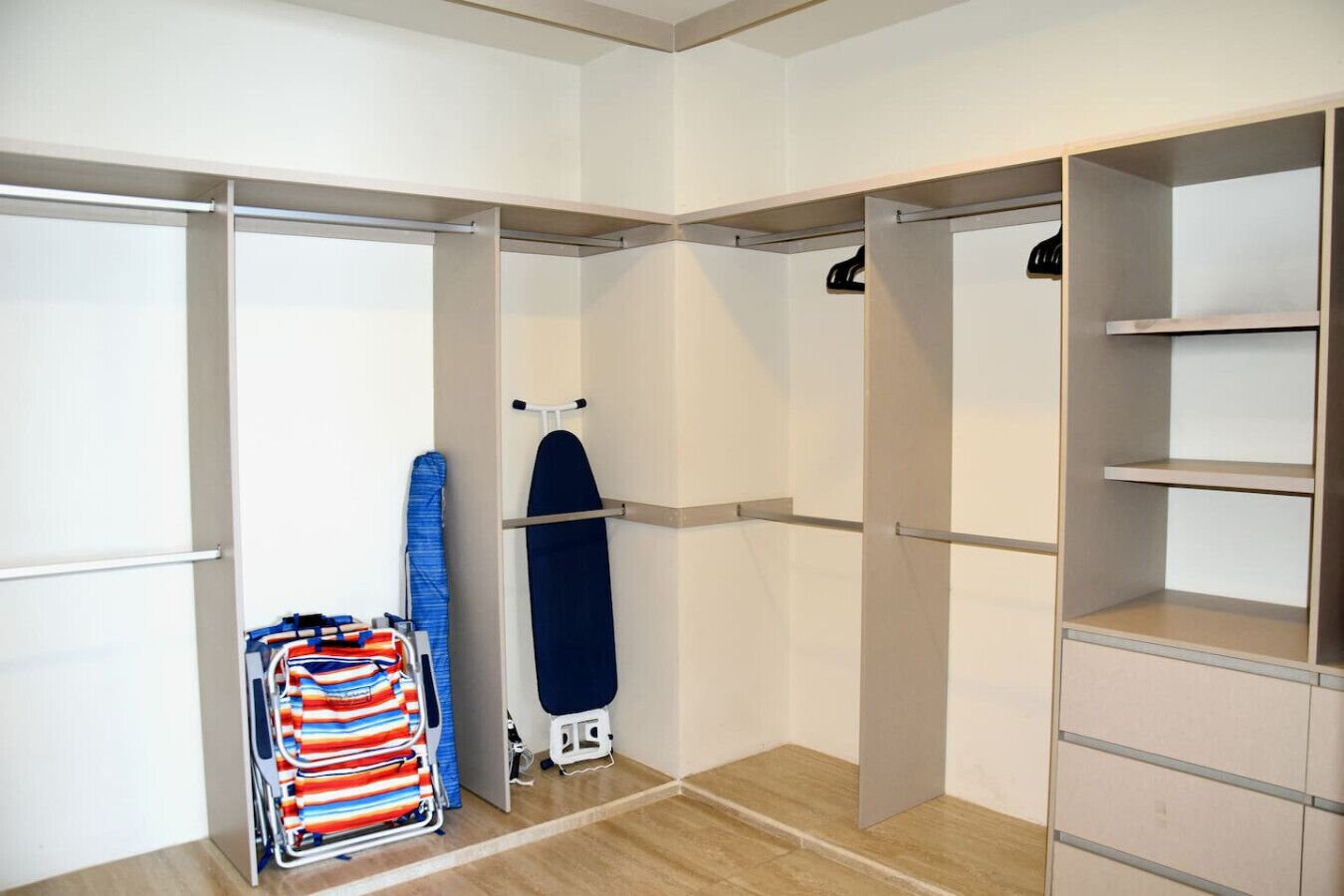 Un dressing accessible sans porte, doté d’étagères ouvertes, d’une tringle à vêtements et d’un présentoir pour les vêtements pliés.