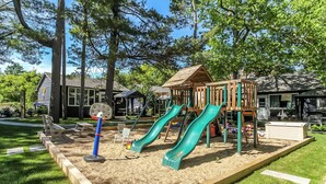 A playground with two slides, sand play area, and wooden structures. - Charming 4-bedroom house with AC, WiFi in brilliant Wasaga Beach (Wasaga Beach)