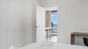 Una habitación de hotel con cama, escritorio y vista al mar.