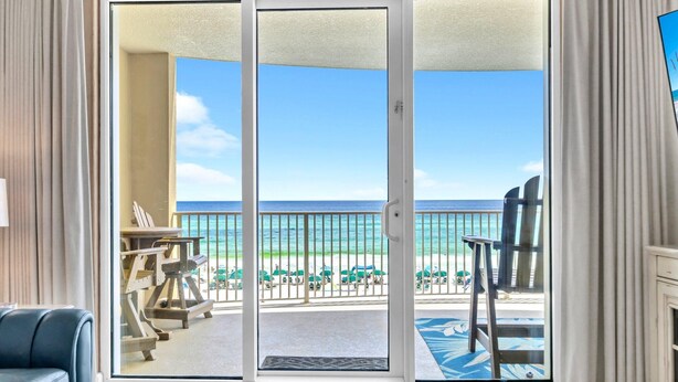 A room with a sliding glass door leading to a balcony with a view of the beach and ocean. - Emerald Isle 403 (Panama City Beach)