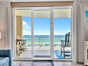 A room with a sliding glass door leading to a balcony with a view of the beach and ocean. - Emerald Isle 403 (Panama City Beach)
