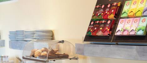 A buffet with various food items, including pastries and pizzas, and a menu board displaying different food options.