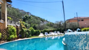 Une piscine dotée de chaises longues et bordée de carreaux.