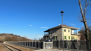 Un quai de gare avec un bâtiment d’un seul étage, une clôture et un lampadaire.