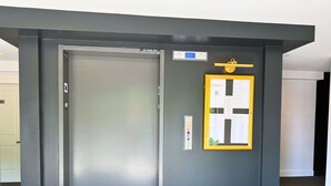 Un ascenseur moderne doté d’un panneau de commande et d’un tableau d’information encadré.