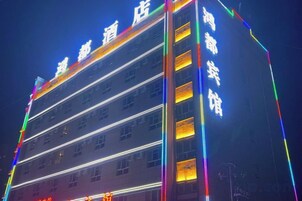 Un hotel de varios pisos con señalización iluminada y fachada moderna.