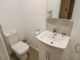 Un baño pequeño y limpio con inodoro, lavamanos y espejo.