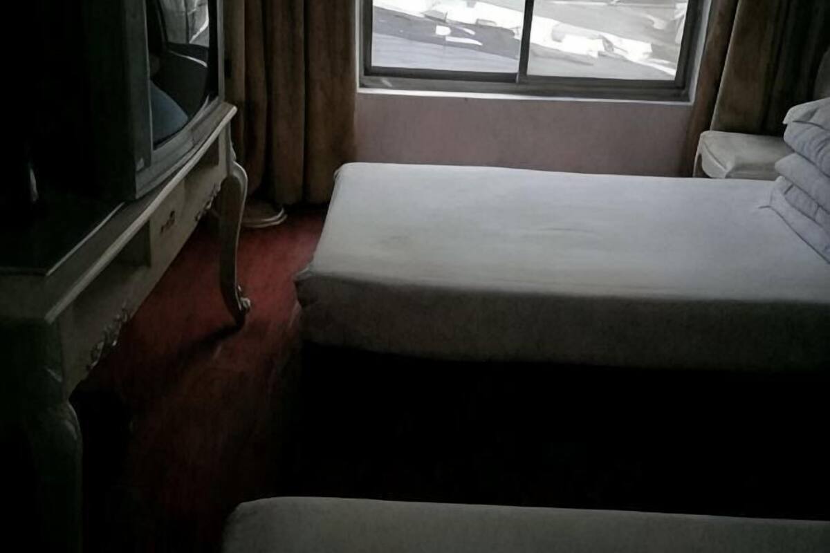 A room with a bed, a window, and a television.