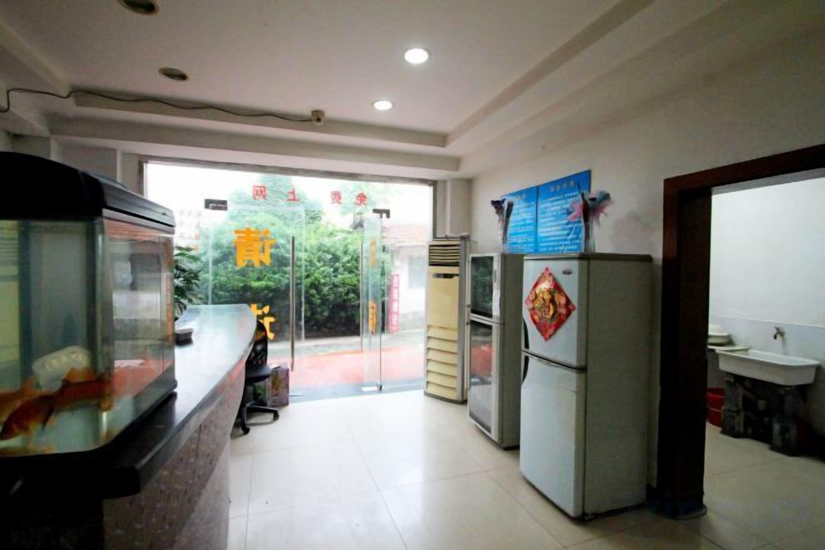 A reception area with a counter, a refrigerator, and a sink.