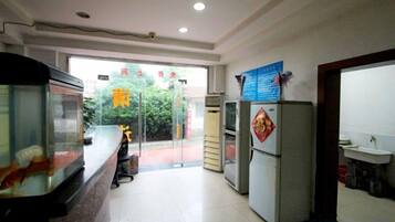 A reception area with a counter, a refrigerator, and a sink.