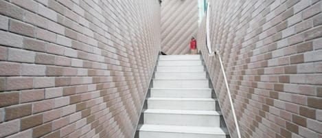 Eine Treppe mit Backsteinwänden auf beiden Seiten, die zu einer höheren Ebene führt.