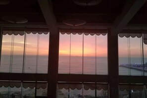 A view through a window with a scalloped design, overlooking a body of water and a distant shoreline. - Beidaihe Bei Hua Yuan Sea View Hotel (Beidaihe Biluo Tower) (Qinhuangdao)