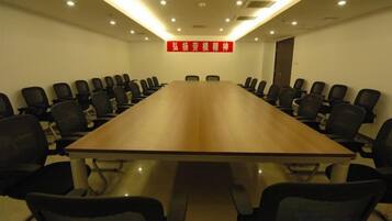 A conference room with a long table and multiple chairs.