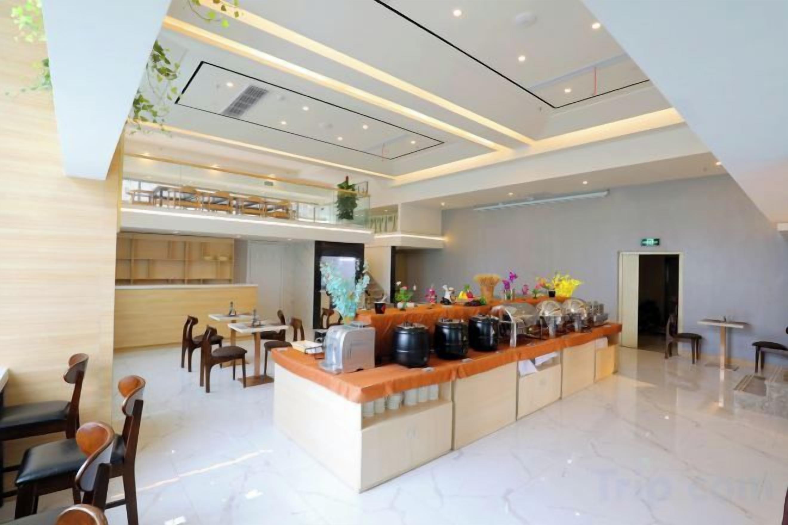 Um saguão de hotel moderno com uma recepção central, área de estar e um mezanino.