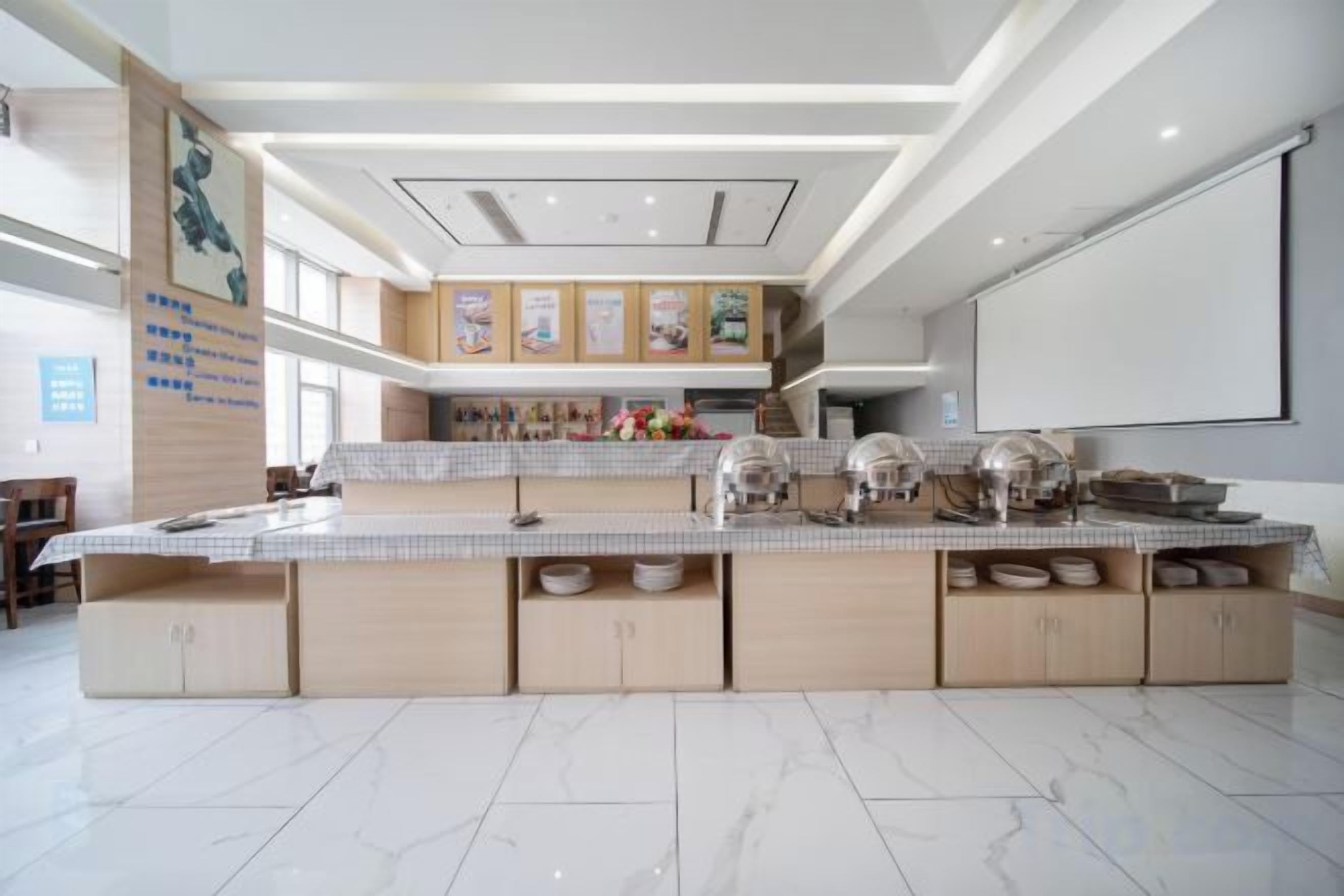 A spacious kitchen with a large island, modern appliances, and a high ceiling with recessed lighting.