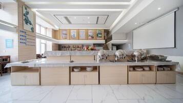 A spacious kitchen with a large island, modern appliances, and a high ceiling with recessed lighting.