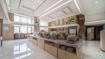 A spacious kitchen with a central island, stainless steel appliances, and a tiled backsplash.