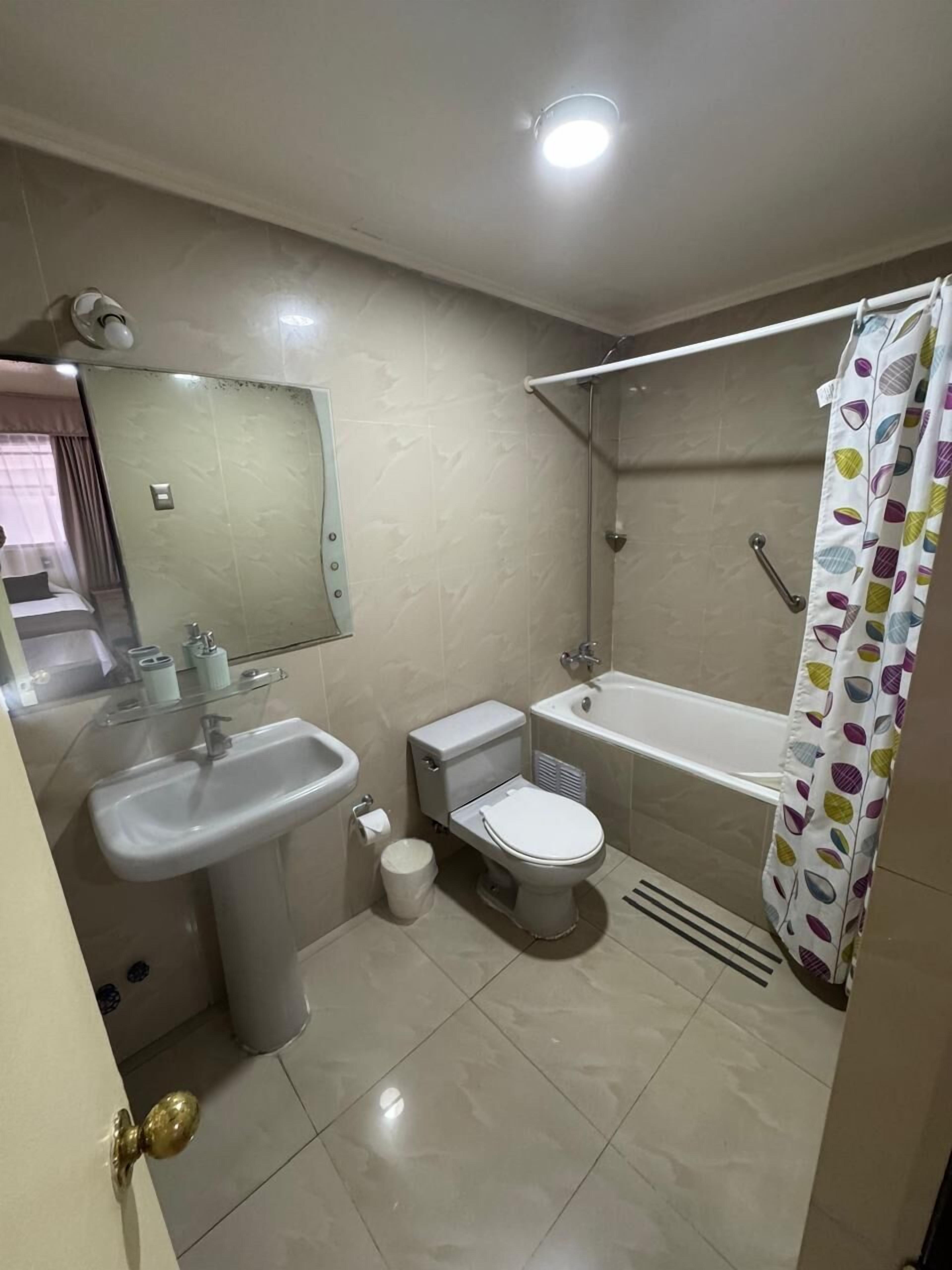 A bathroom with a sink, toilet, bathtub, and shower curtain.