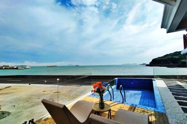 Un espace piscine avec vue sur la mer et accès à la plage.