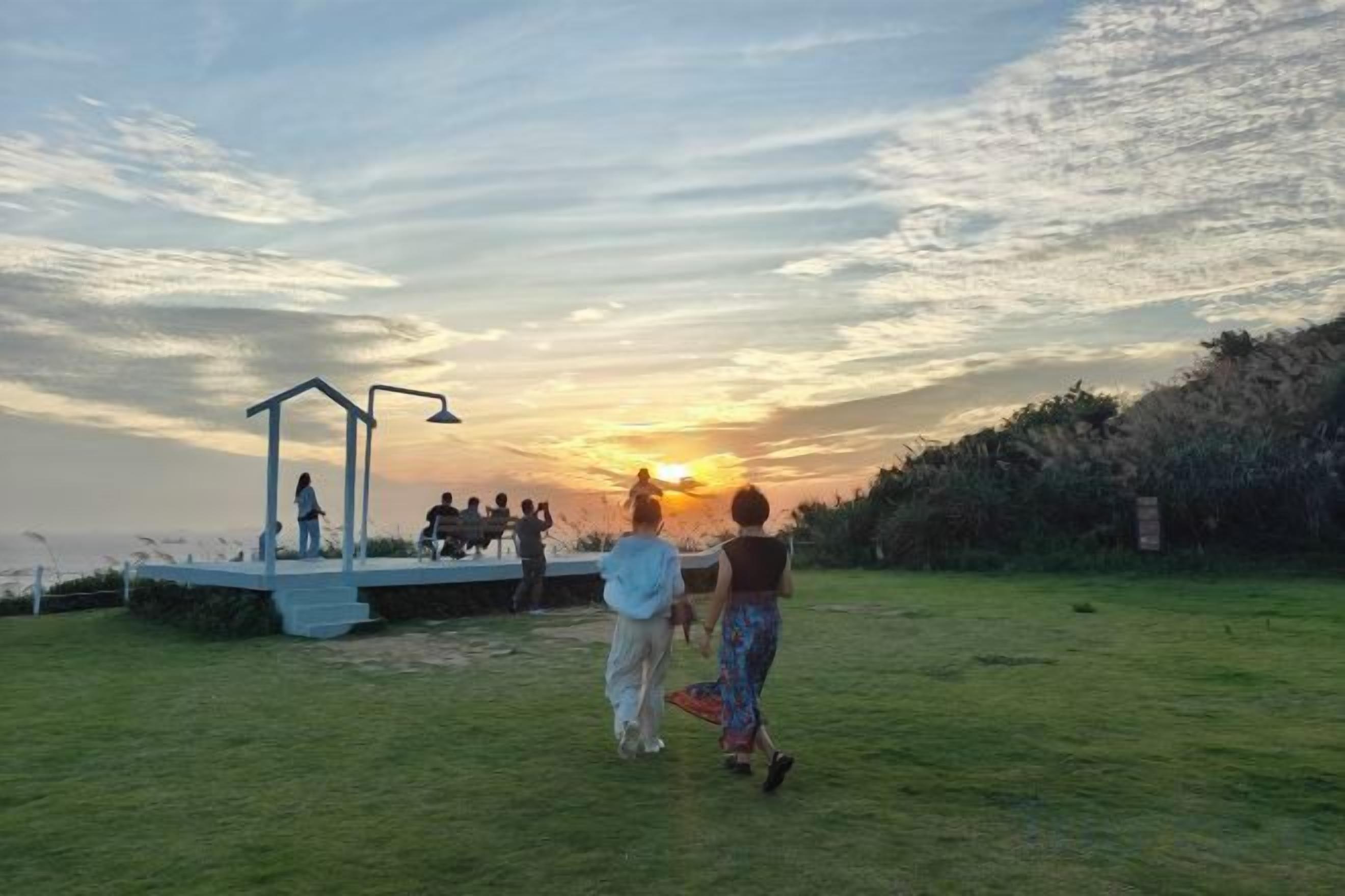 A grassy outdoor area with a stage and a gazebo.