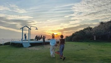 A grassy outdoor area with a stage and a gazebo.