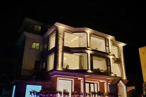 Un immeuble à plusieurs étages doté de grandes fenêtres et d’un balcon.