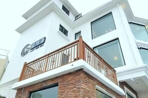 Un immeuble à plusieurs étages doté d’un balcon avec une balustrade en bois.