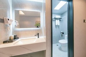A modern bathroom with a white sink, a mirror, a hairdryer, and a toilet. - Yuelin Hotel (Fuzhou)