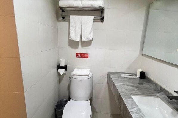 A small bathroom with a toilet, a sink, and a towel rack.